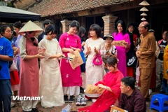 Nhóm du khách Hàn Quốc trải nghiệm với di sản Tranh Đông Hồ của Việt Nam. (Ảnh: Xuân Mai/Vietnam+)