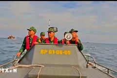 Cán bộ, chiến sỹ đồn Biên phòng tại Cô Tô kêu gọi tàu thuyền vào nơi tránh trú bão số 9. (Ảnh: TTXVN phát)