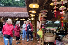 Du khách quốc tế tham quan không gian trưng bày sản phẩm làng nghề truyền thống ở Văn Miếu-Quốc Tử Giám. (Ảnh: Mai Mai/Vietnam+)
