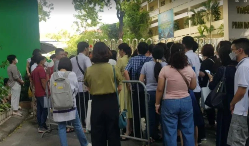 Phu hynh xếp hàng nộp hồ sơ cho con vào lớp 10 Trường Trung học phổ thông Phan Huy Chú. (Ảnh: PV/Vietnam+).