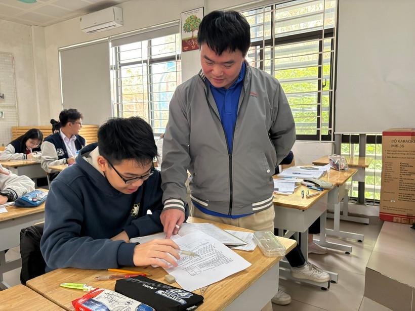 Thầy Nguyễn Đăng Lâm hướng dẫn học sinh làm bài. (Ảnh: PM/Vietnam+).