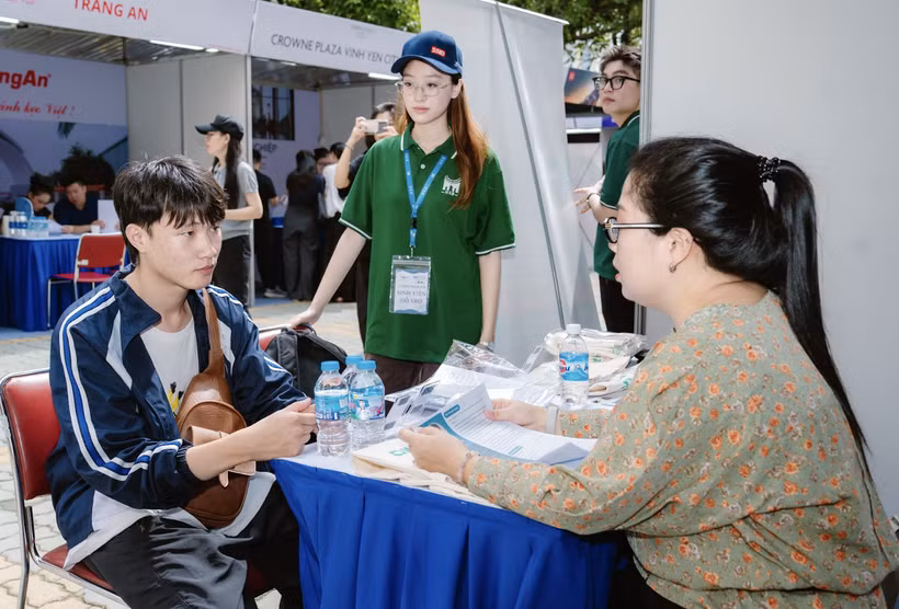 Sinh viên Trường Quản trị và Kinh doanh, Đại học Quốc gia Hà Nội trao đổi tìm hiểu về cơ hội việc làm. (Ảnh: PV/Vietnam+)
