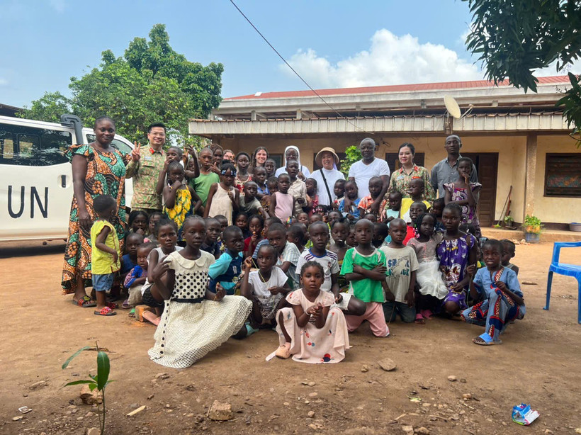 Ông Salim - Giám đốc Trung tâm (đứng ở giữa) cùng các em nhỏ chụp ảnh kỉ niệm cùng Tổ công tác. (Ảnh: PV/Vietnam+)