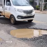 Một xe tải lưu thông qua vị trí mặt đường Nguyễn Huệ bị lún sâu, bong bật lớp nhựa và đọng nước, cho thấy mức độ xuống cấp của tuyến đường. (Ảnh: Đậu Tất Thành/TTXVN.)