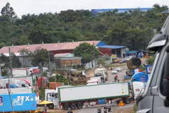 Xe container di chuyển vào bãi tập kết và chắn ngang đường trên quốc lộ 26. (Ảnh: Tuấn Anh/TTXVN)