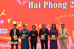 Lãnh đạo Hội Liên lạc Việt kiều tặng kiều bào sách dạy tiếng Việt cho trẻ em. (Ảnh: Minh Thu/TTXVN)