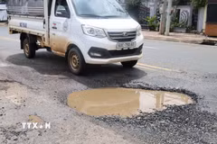Một xe tải lưu thông qua vị trí mặt đường Nguyễn Huệ bị lún sâu, bong bật lớp nhựa và đọng nước, cho thấy mức độ xuống cấp của tuyến đường. (Ảnh: Đậu Tất Thành/TTXVN.)