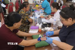 Lấy mẫu sinh phẩm ADN của thân nhân các liệt sỹ. (Ảnh: Hương Thu.TTXVN)