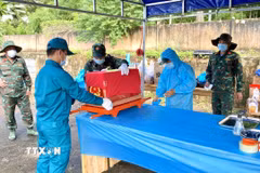 Ban Chỉ đạo về tìm kiếm, quy tập và xác định danh tính hài cốt liệt sỹ tỉnh An Giang lấy mẫu hài cốt phục vụ giám định ADN tại Nghĩa trang Liệt sỹ Tri Tôn. (Ảnh: Thanh Sang/TTXVN)