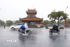 Người dân đi lại trong mưa lớn tại thành phố Huế. (Ảnh: Nguyên Lý/TTXVN)