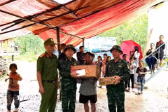 Các lực lượng chức năng thăm hỏi, động viên gia đình nạn nhân. (Ảnh: TTXVN phát)