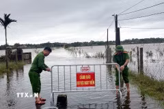 Công an xã Bến Hải (Quảng Trị) lập rào chắn, khuyến cáo người dân tuyệt đối không di chuyển qua các tuyến đường nước ngập sâu. (Ảnh: TTXVN phát)
