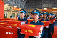 Di chuyển mẫu hài cốt các liệt sỹ từ máy bay đến vị trí làm lễ dâng hương. (Ảnh: Trọng Đức/TTXVN)