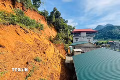 Các hộ dân ở ngay dưới taluy dương, sạt lở đất đá gây nguy hiểm nghiêm trọng tới các hộ gia đình này. (Ảnh: TTXVN phát)