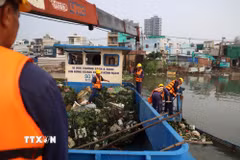 Công nhân Công ty Trách nhiệm hữu hạn Một thành viên Dịch vụ công ích Quận 8 vớt rác trên kênh Đôi, đoạn qua phường Phú Định. (Ảnh: Hồng Đạt/TTXVN)