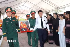 Thiếu tướng Lương Đình Chung, Bí thư Đảng uỷ Chính uỷ Quân khu và đồng chí Nguyễn Đức Tuy, Phó Bí thư Tỉnh uỷ, Chủ tịch HĐND tỉnh Quảng Ngãi, đưa liệt sĩ về nơi an nghỉ. (Ảnh: Đinh Hương/TTXVN)