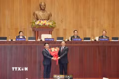Chủ tịch Quốc hội Lào khóa X Sonexay Siphandone (phải) tặng hoa chúc mừng Thủ tướng Chính phủ Lào khóa X Saleumxay Kommasit. (Ảnh: Xuân Tú/TTXVN)
