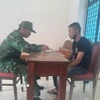 Cán bộ nghiệp vụ thuộc Đồn Biên phòng Cửa khẩu quốc tế Mộc Bài làm việc với đối tượng Phạm Minh Hải. (Ảnh: TTXVN phát)