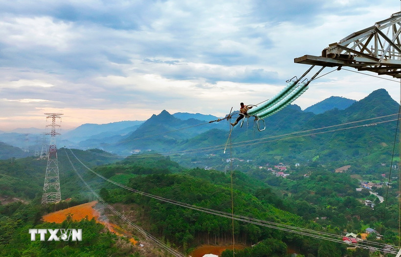 Công nhân ngành điện triển khai kéo cáp dây điện trên vị trí cột số 18,17 của dự án đường dây 500kV, thuộc xã Xuân Quang, tỉnh Lào Cai. (Ảnh: Vũ Sinh/TTXVN)