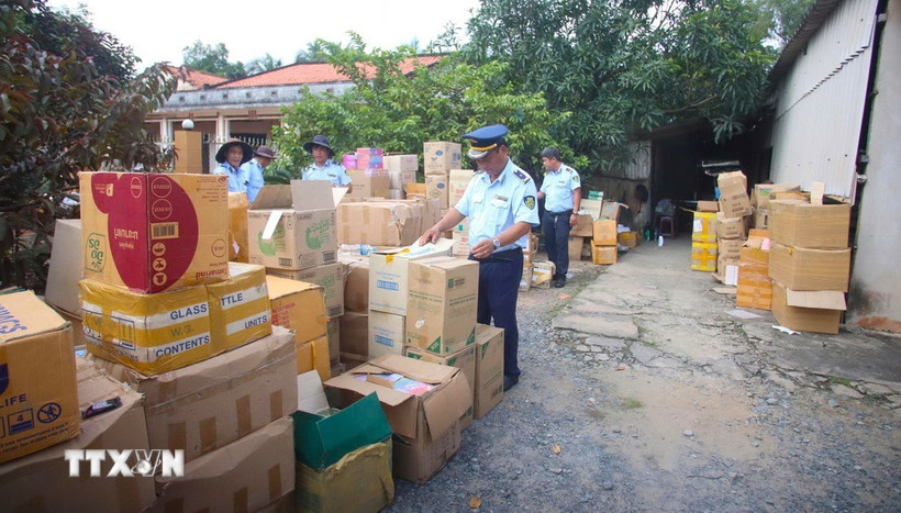 Lực lượng quản lý thị trường tỉnh Tây Ninh kiểm tra kho hàng tại hộ kinh doanh B.N. (ấp Bà Phổ, xã Thủ Thừa, tỉnh Tây Ninh) nghi giả mạo nhãn hiệu, không rõ nguồn gốc. (Ảnh: Minh Phú/TTXVN)