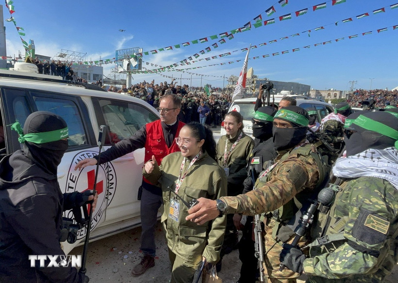 Các thành viên Lữ đoàn Al-Qassam và Al-Quds tiến hành lễ trao trả 4 nữ binh sĩ Israel cho Ủy ban Chữ thập đỏ quốc tế (ICRC) tại thành phố Gaza, ngày 25/1/2025. (Ảnh: AA/TTXVN)