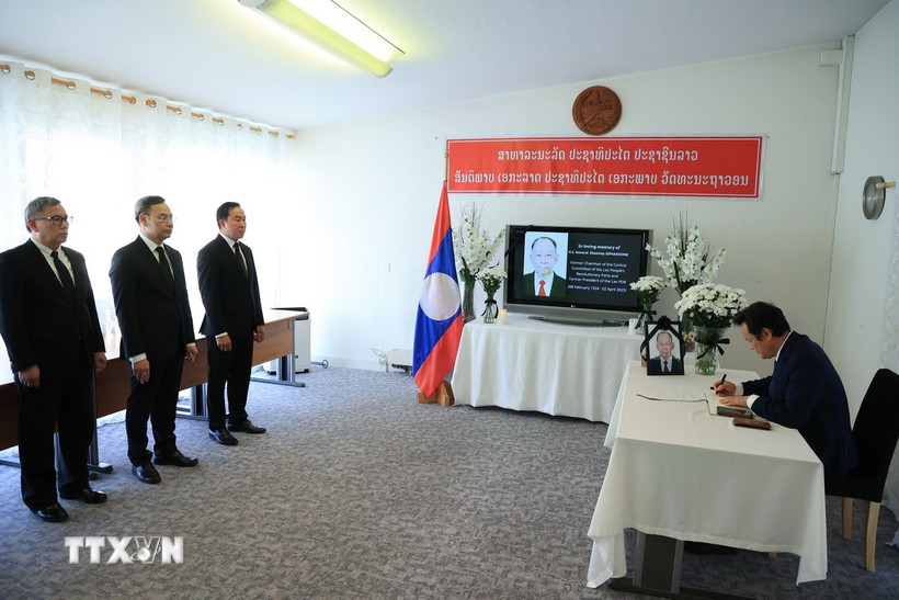 Đại sứ Mai Phan Dũng, Trưởng Phái đoàn Thường trực Việt Nam tại Geneva ghi sổ tang tại Phái đoàn Lào tại Geneva. (Ảnh: Anh Hiển/TTXVN)