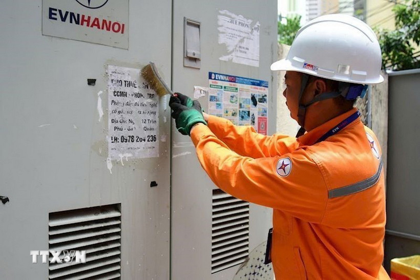 Công nhân EVNHANOI thực hiện bóc xóa quảng cáo rao vặt tại trạm biến áp thuộc phường Hà Đông. (Ảnh: Quốc Lũy/TTXVN)