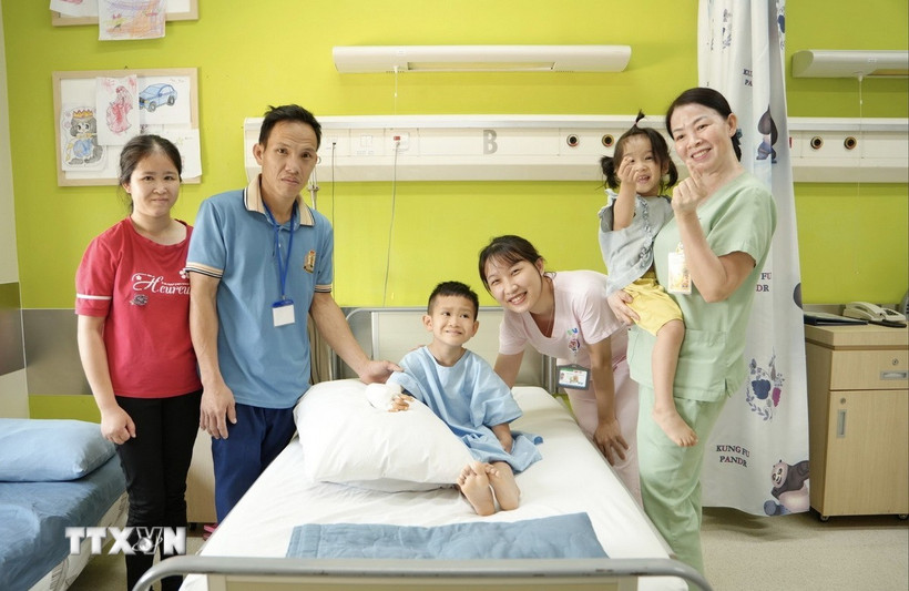 Niềm vui của gia đình bé Lê Duy Quang (11 tuổi, ngụ tỉnh Hà Tĩnh) sau phẫu thuật lần 1. (Ảnh: TTXVN phát)