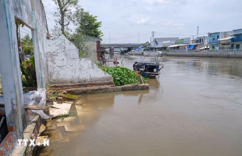Điểm sạt lở trên kênh Nàng Mau, xã Thạnh Hòa, thành phố Cần Thơ làm một căn nhà bị sụp hoàn toàn xuống sông. (Ảnh: Thanh Liêm/TTXVN)