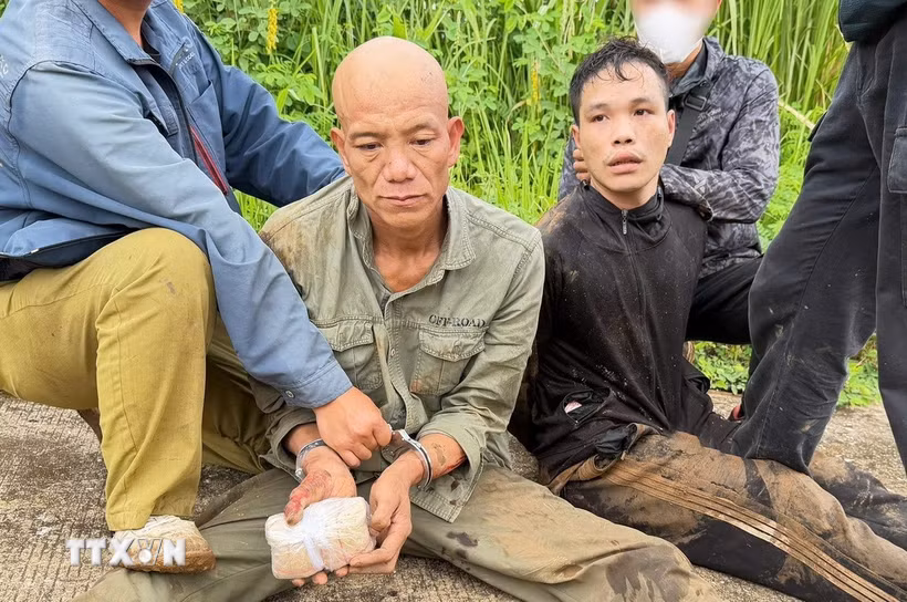 (Hai đối tượng và tang vật. Ảnh: TTXVN phát)