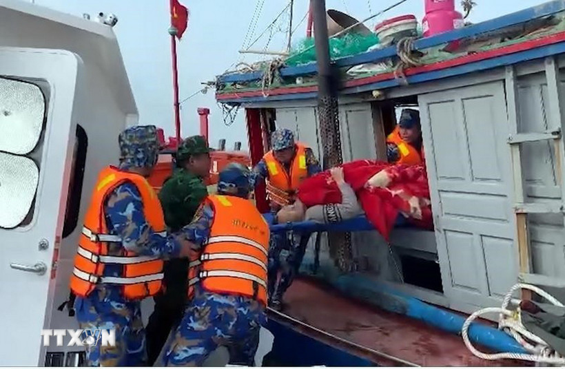 Cán bộ Hải đội Biên phòng 2, Ban Chỉ huy BĐBP tỉnh Ninh Bình cứu nạn và đưa nạn nhân vào bờ. (Ảnh: TTXVN phát)