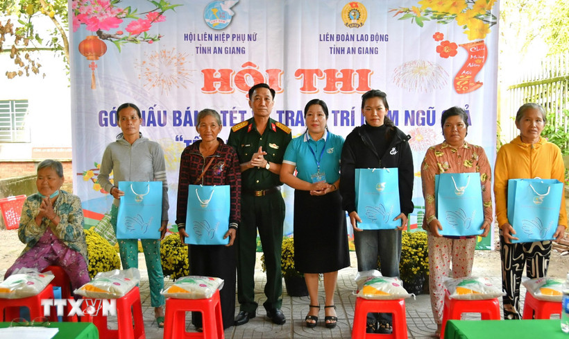 Đại tá Cao Minh Tâm, Phó Chính ủy Bộ Chỉ huy quân sự tỉnh và Phó Chủ tịch Hội Liên hiệp phụ nữ tỉnh An Giang Lê Thị Ngọc Dung trao quà cho người dân khó khăn xã Hòa Điền dịp tết Quân - Dân 2026. (Ảnh: Văn Sĩ/TTXVN)
