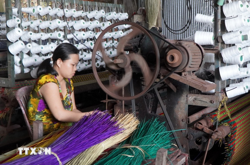 Người dân Làng chiếu Định Yên (huyện Lấp Vò) sử dụng máy dệt thay cho dệt thủ công để nâng cao năng suất lao động. (Ảnh: Nhựt An/TTXVN)