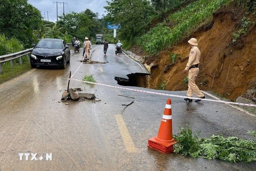 Cảnh sát giao thông hướng dẫn phân luồng tại điểm lún, sạt trên Km25+300 Quốc lộ 4D thuộc bản Hồng Thu, xã Lản Nhì Thàng, huyện Phong Thổ, tỉnh Lai Châu. (Ảnh: TTXVN phát)