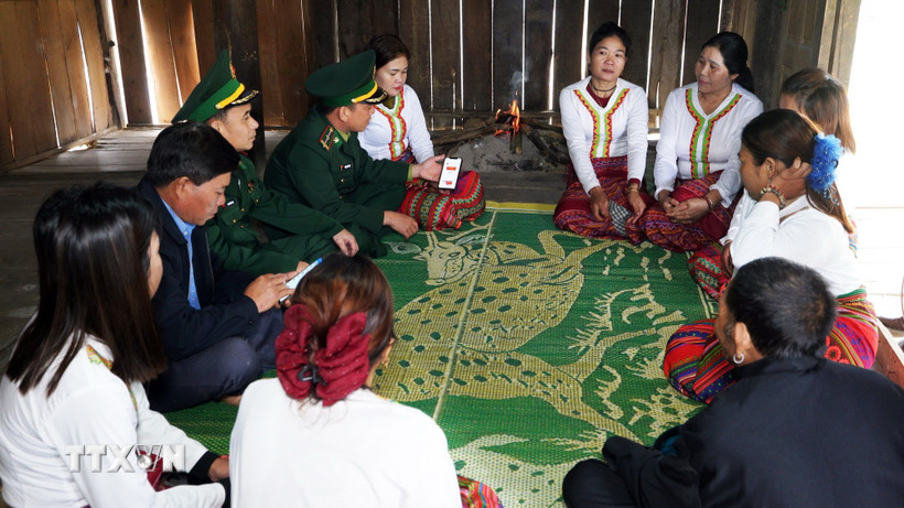 Lực lượng biên phòng và các già làng, trưởng bản đến từng hộ gia đình người Chứt ở bản Rào Tre để tuyên truyền về công tác bầu cử. (Ảnh: Hữu Quyết/TTXVN)