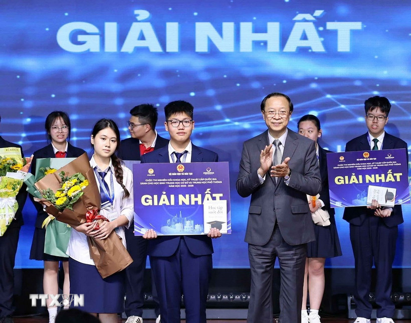 Thứ trưởng Thường trực Bộ Giáo dục và Đào tạo Phạm Ngọc Thưởng trao giải Nhất cho các học sinh đạt giải. (Ảnh: Thanh Tùng/TTXVN)