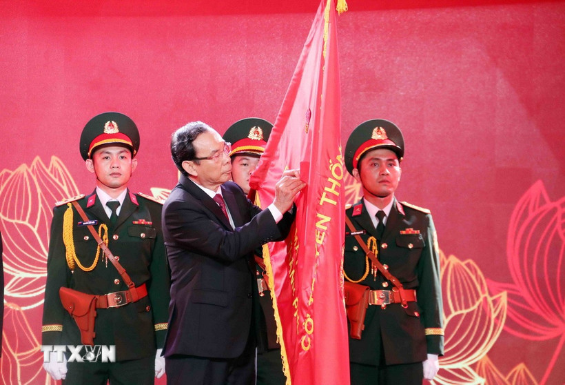 Bí thư Thành ủy Thành phố Hồ Chí Minh Nguyễn Văn Nên gắn danh hiệu Anh hùng Lao động lên cờ truyền thống của Ủy ban MTTQ Việt Nam Thành phố Hồ Chí Minh. (Ảnh: Xuân Khu/TTXVN)