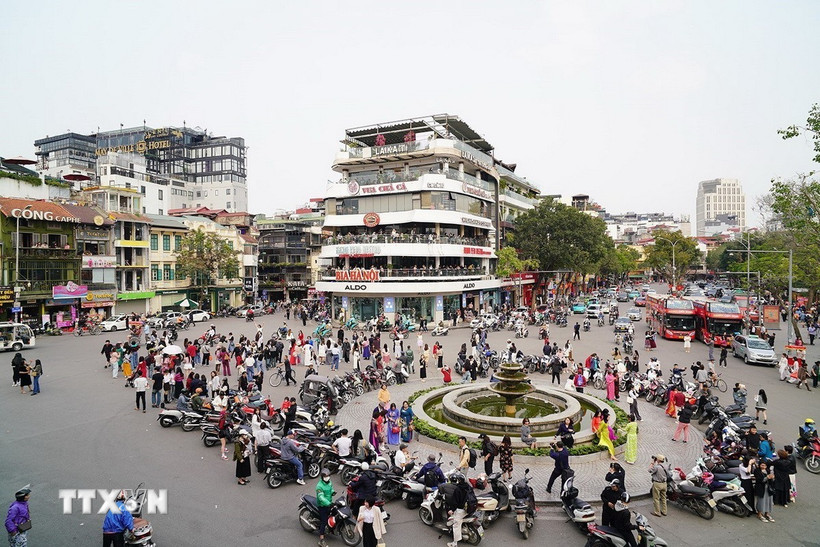 Người dân tụ tập chụp ảnh trước thời điểm phá dỡ tòa nhà "Hàm cá mập". (Ảnh: Khánh Hòa/TTXVN)