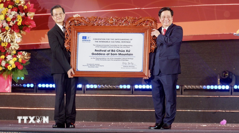 Bí thư Tỉnh ủy An Giang Lê Hồng Quang (trái) thay mặt lãnh đạo tỉnh đón nhận Bằng UNESCO ghi danh “Lễ hội Vía Bà Chúa Xứ Núi Sam” vào danh sách Di sản Văn hóa phi vật thể đại diện của nhân loại. (Ảnh: Thanh Sang/TTXVN)