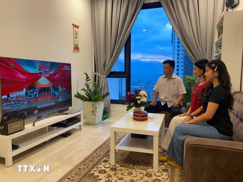 Gia đình anh Lê Văn Hùng xem truyền hình trực tiếp buổi lễ kỷ niệm 50 năm Ngày Giải phóng miền Nam, thống nhất đất nước. (Ảnh: Hằng Linh/TTXVN)