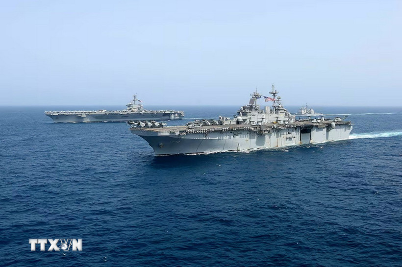 Tàu sân bay USS Abraham Lincoln (phía sau) của hải quân Mỹ di chuyển trên Biển Arab. (Ảnh: AP/TTXVN)