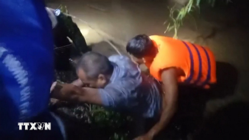 Lực lượng cứu hộ xã Đồng Xuân, tỉnh Đắk Lắk, phối hợp với người dân ứng cứu 2 nạn nhân. (Ảnh: TTXVN phát)