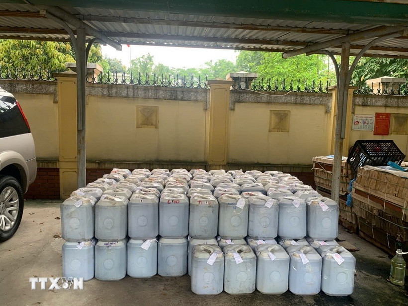 Hàng ngàn lít nước mắm được đóng vào các can nhựa bị lực lượng chức năng phát hiện. (Ảnh: TTXVN phát)