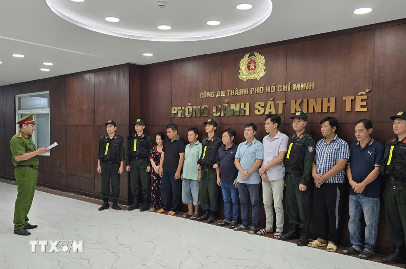 Cơ quan điều tra tống đạt quyết định khởi tố đối với các đối tượng. (Ảnh: TTXVN phát)