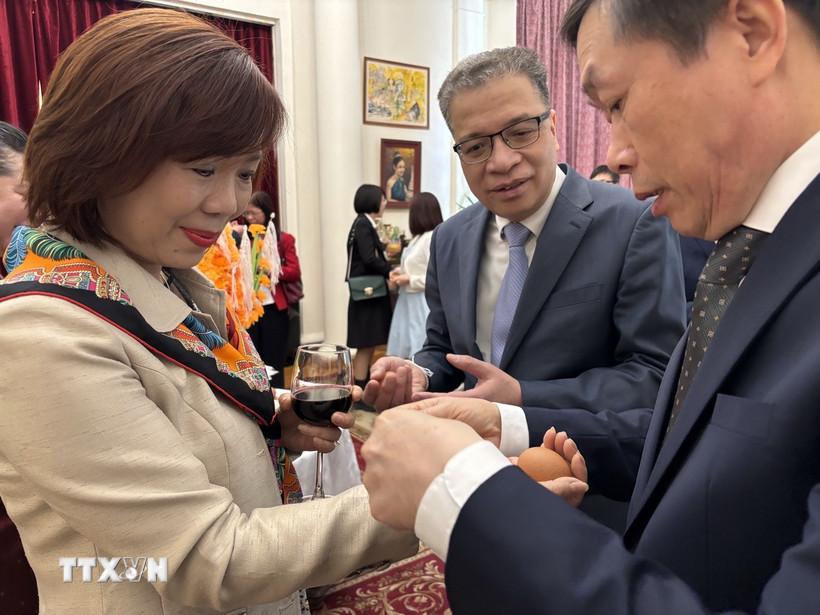 Phong tục buộc chỉ cổ tay để chúc mừng Năm mới trong Tết Bunpimay của Lào. (Ảnh: Tâm Hằng/TTXVN)