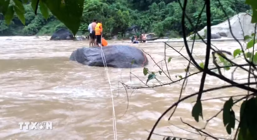 Chiến sỹ Đồn Biên phòng Pa Vệ Sử, Lai Châu, kịp thời cứu 3 người dân bị mắc kẹt giữa dòng nước lũ tại khu vực hồ thủy điện Nậm Sì Lường, xã Bum Nưa, tỉnh Lai Châu. (Ảnh: TTXVN phát)