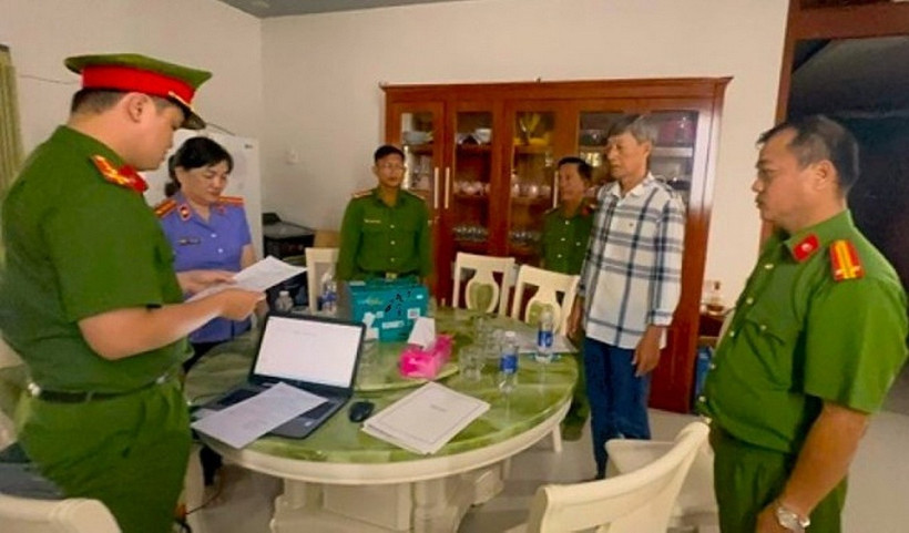 Công an đọc lệnh khởi tố bị can Nguyễn Thành Sua (áo kẻ). (Ảnh: Công an tỉnh Cà Mau)