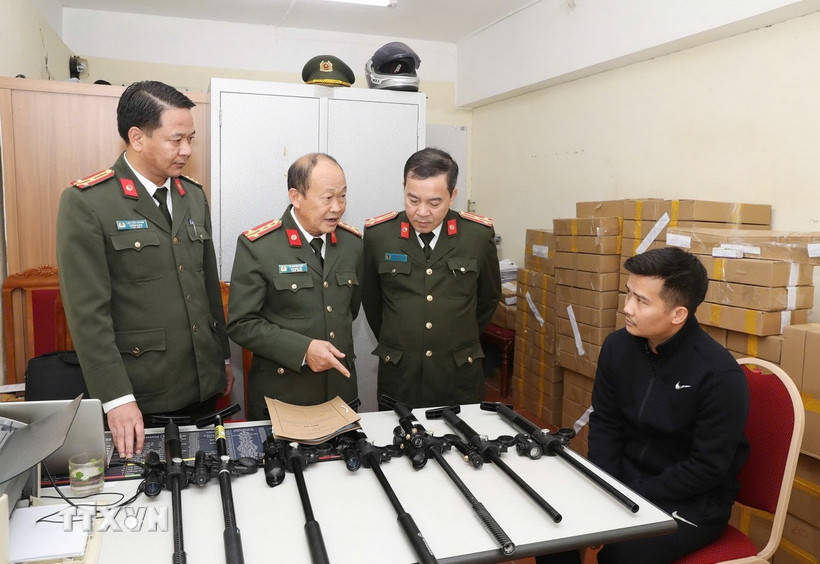 Đối tượng Vi Văn Duy (ngồi) cùng tang vật bị thu giữ. (Ảnh: TTXVN phát)