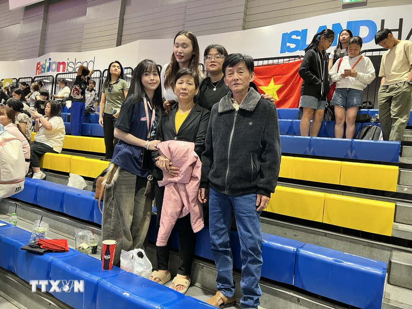 Châu Tuyết Vân (ngoài cùng bên trái) “cô gái vàng” của Teakwondo Việt Nam từng đoạt 8 Huy chương Vàng SEA Games, cùng bố mẹ tới sân cổ vũ cho đội tuyển Việt Nam. (Ảnh: Đỗ Sinh/TTXVN)