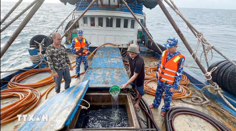 Lực lượng chức năng Bộ Tư lệnh Vùng Cảnh sát biển 4 kiểm tra hàng hóa trên tàu cá TG 92232 TS. (Ảnh: TTXVN phát)